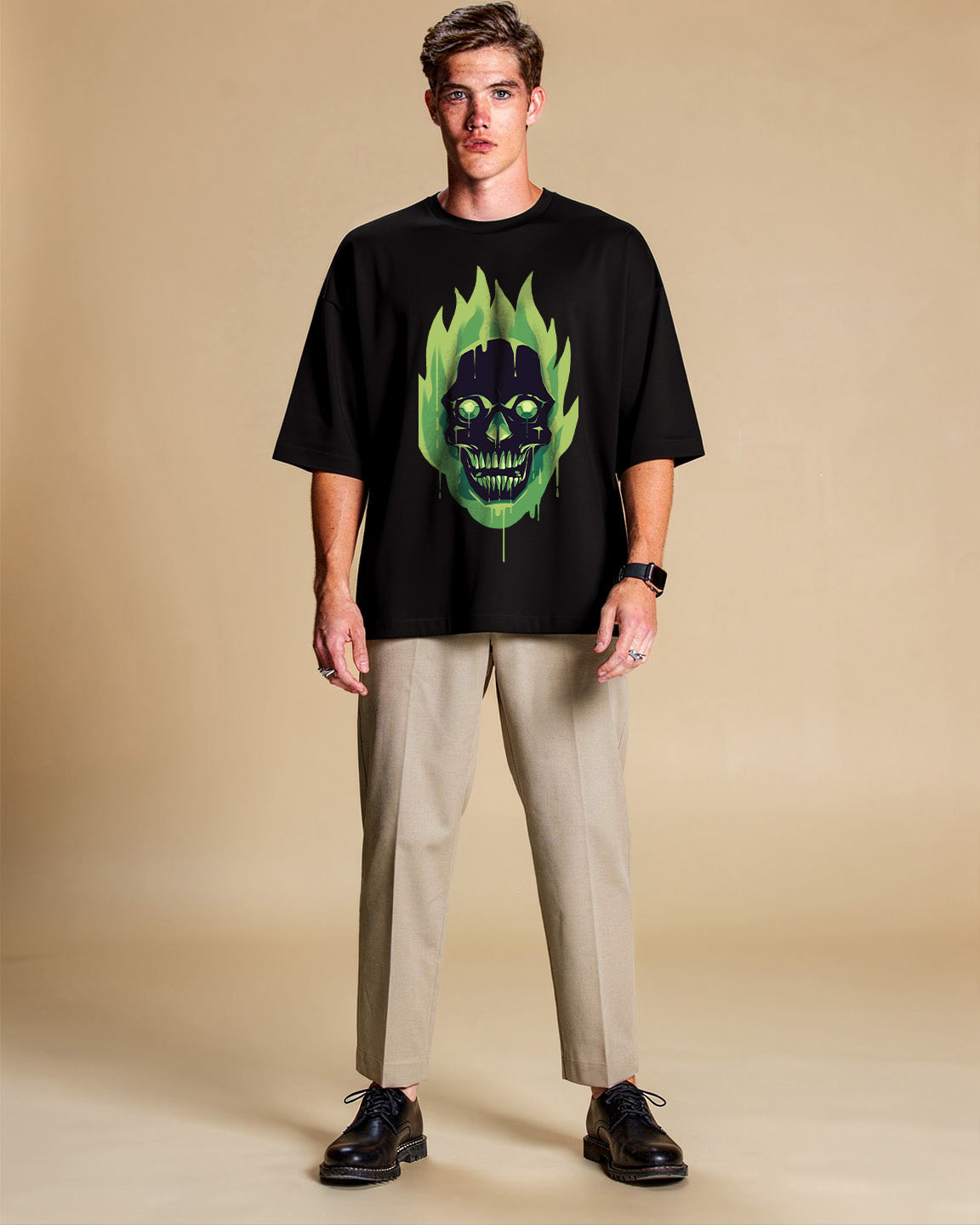 Man wearing a black t-shirt with a green and black graphic design on a beige background
