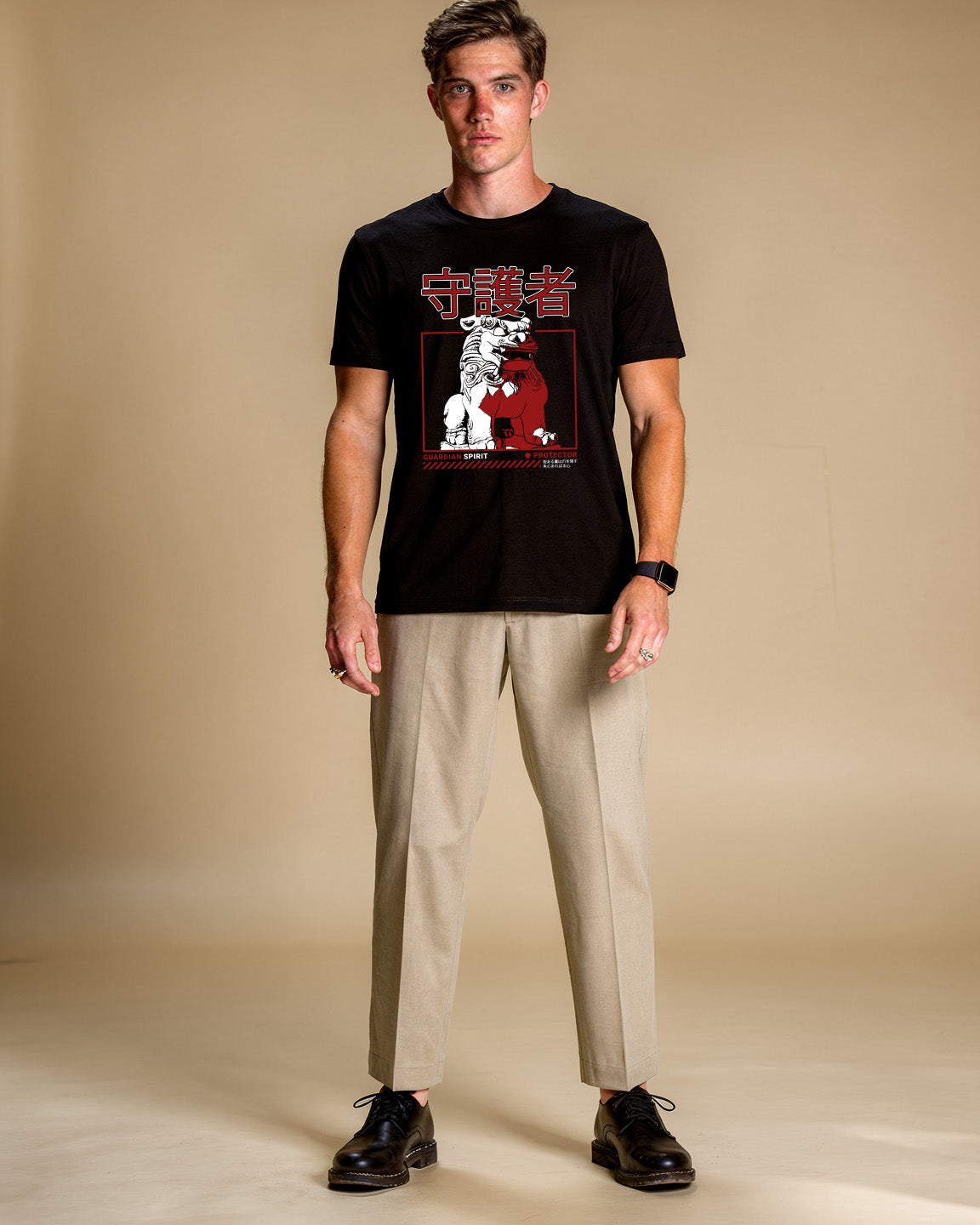 Man wearing a black t-shirt with a graphic design on a beige background