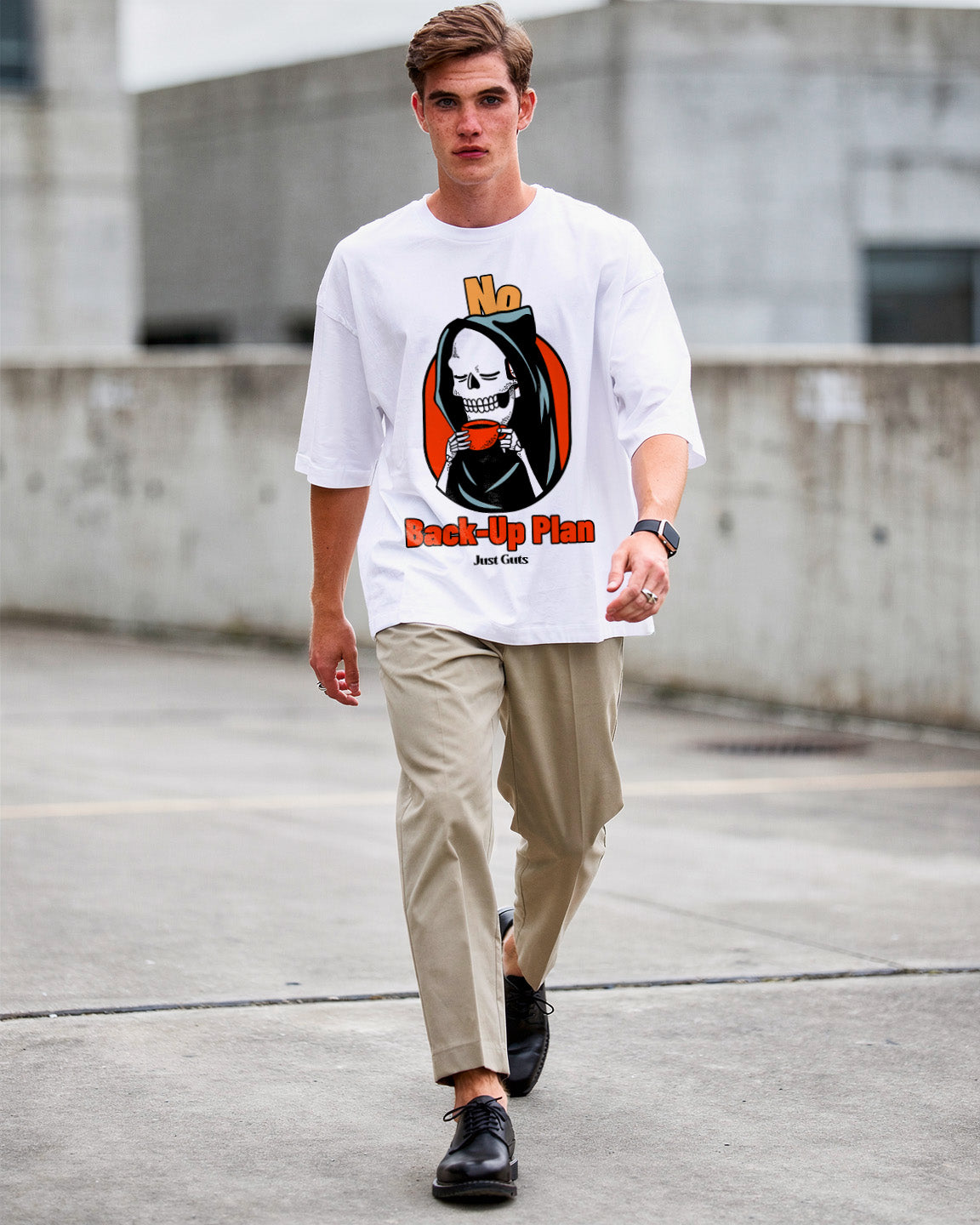 Man wearing a white t-shirt with a graphic design, walking on a concrete surface.
