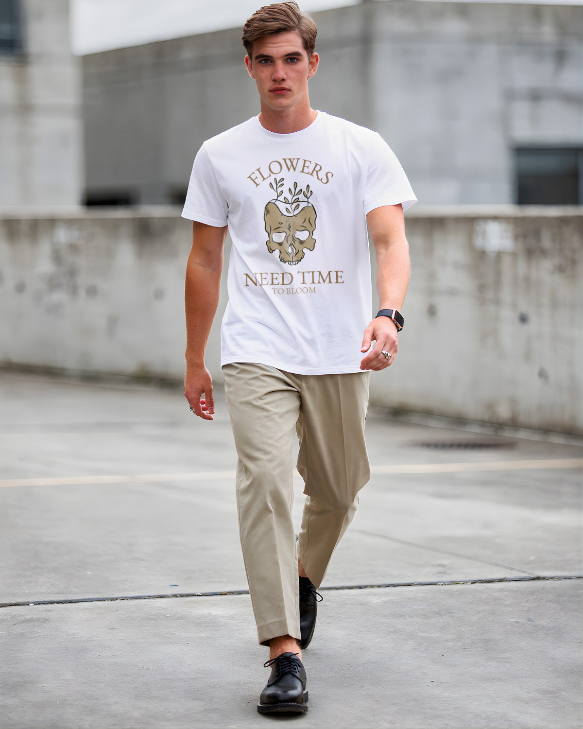 Man wearing a white t-shirt with a graphic design and text, walking on a concrete surface.
