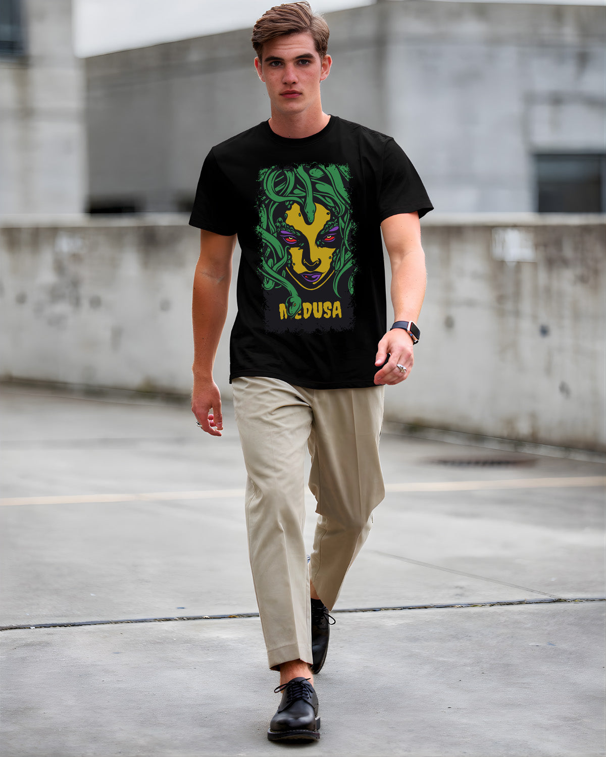 Man wearing a black t-shirt with a colorful graphic design, walking on a concrete surface.
