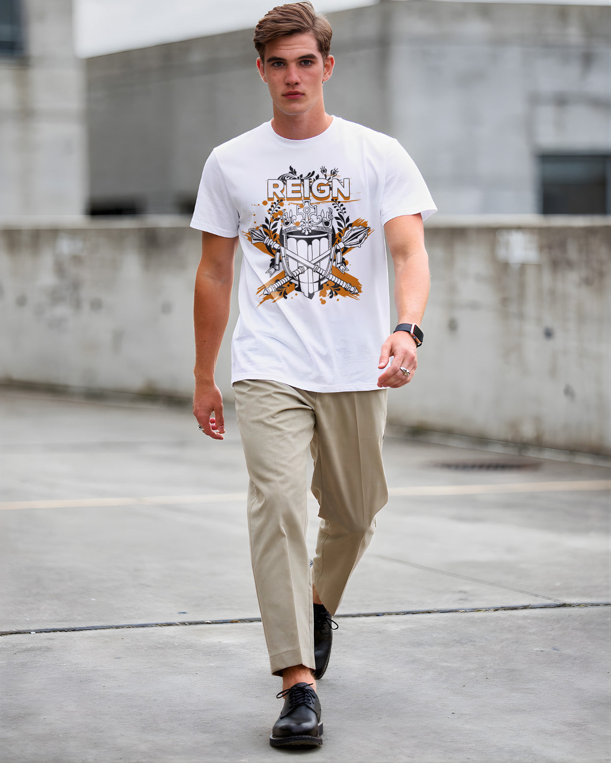 Man wearing a white t-shirt with graphic design and beige pants walking on a concrete surface.