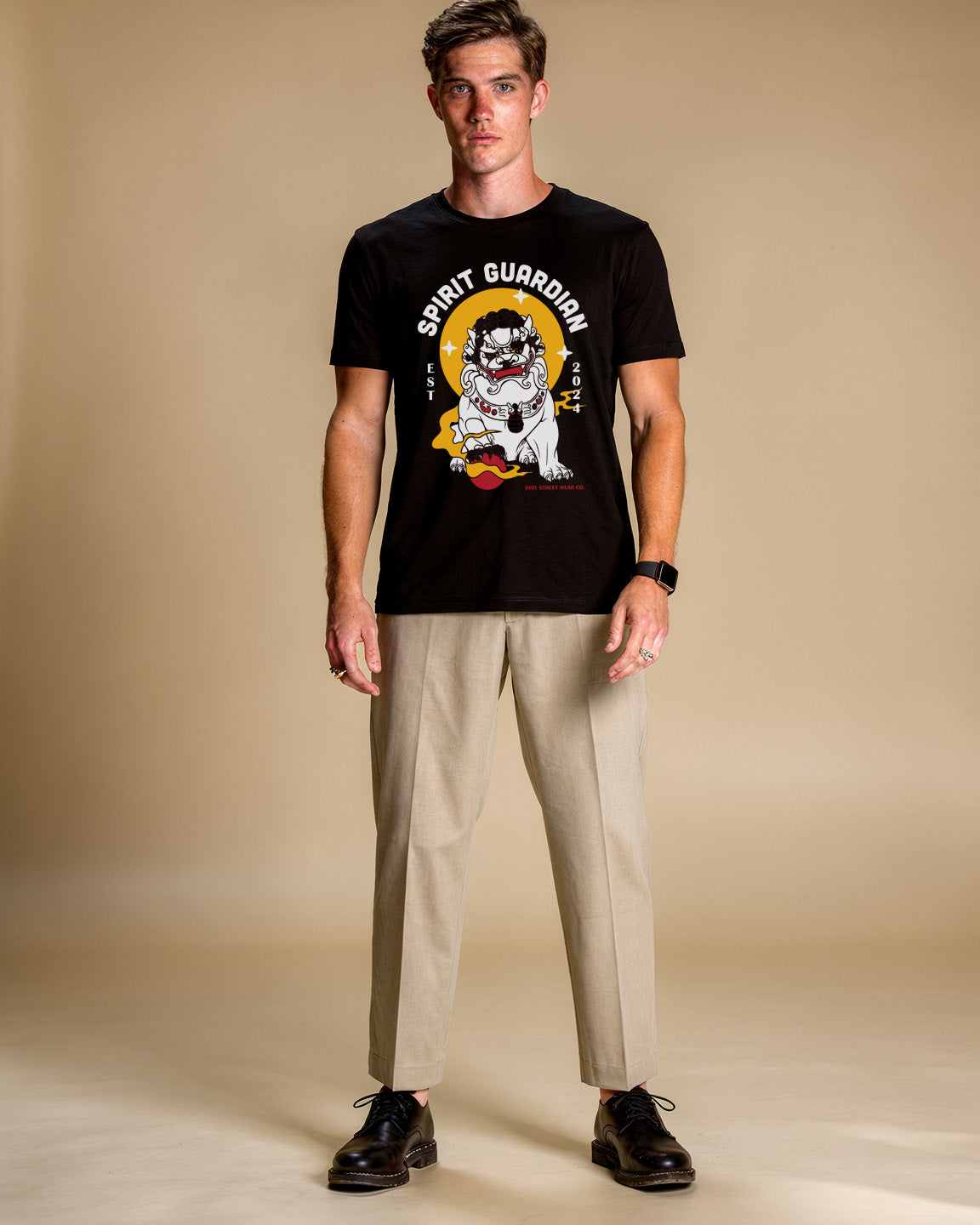 Man wearing a black t-shirt with a graphic design on a beige background
