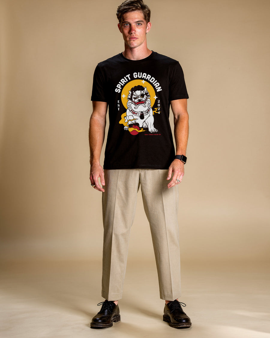 Man wearing a black t-shirt with a graphic design on a beige background